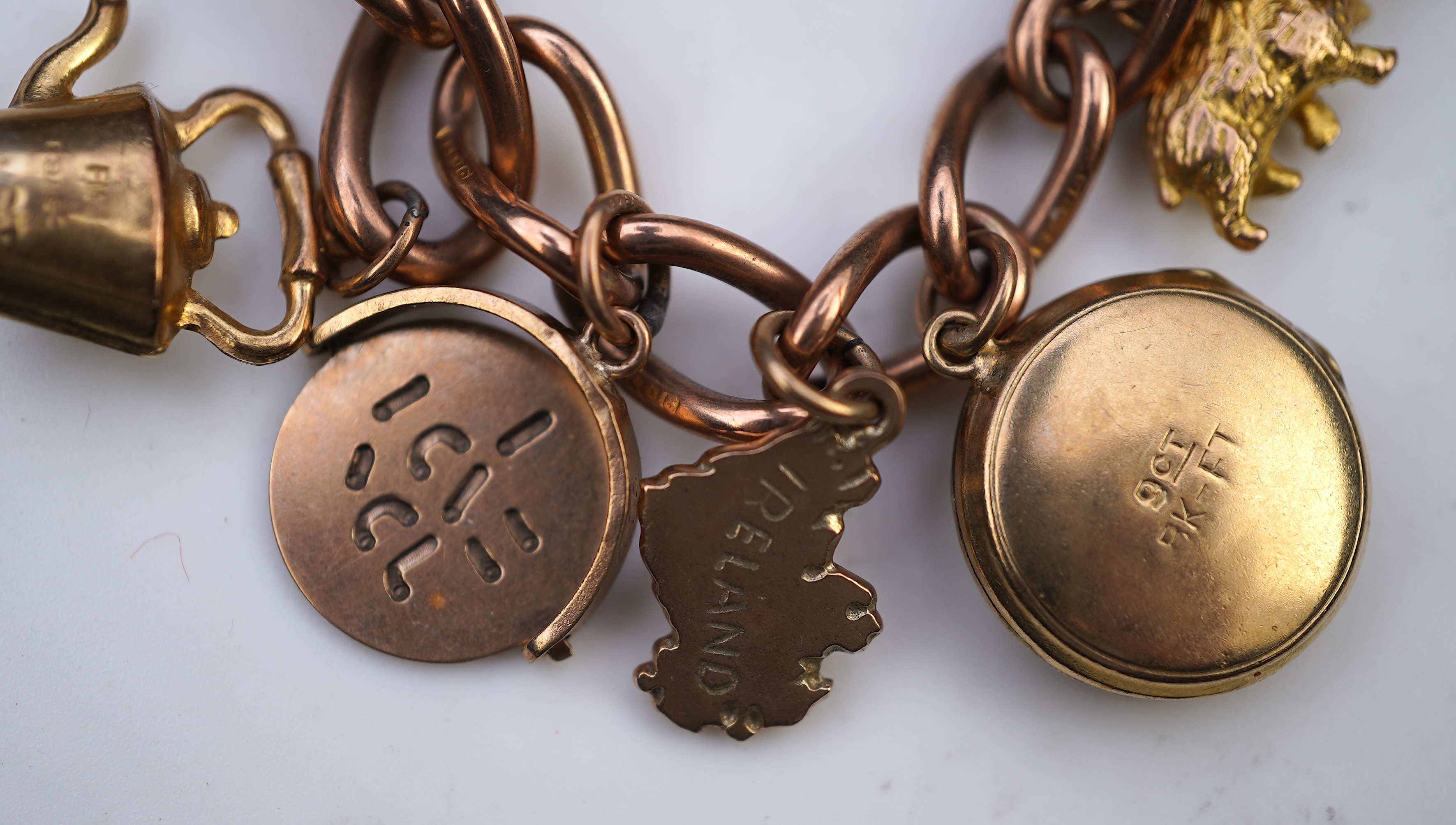 A gold charm bracelet, mid 20th century